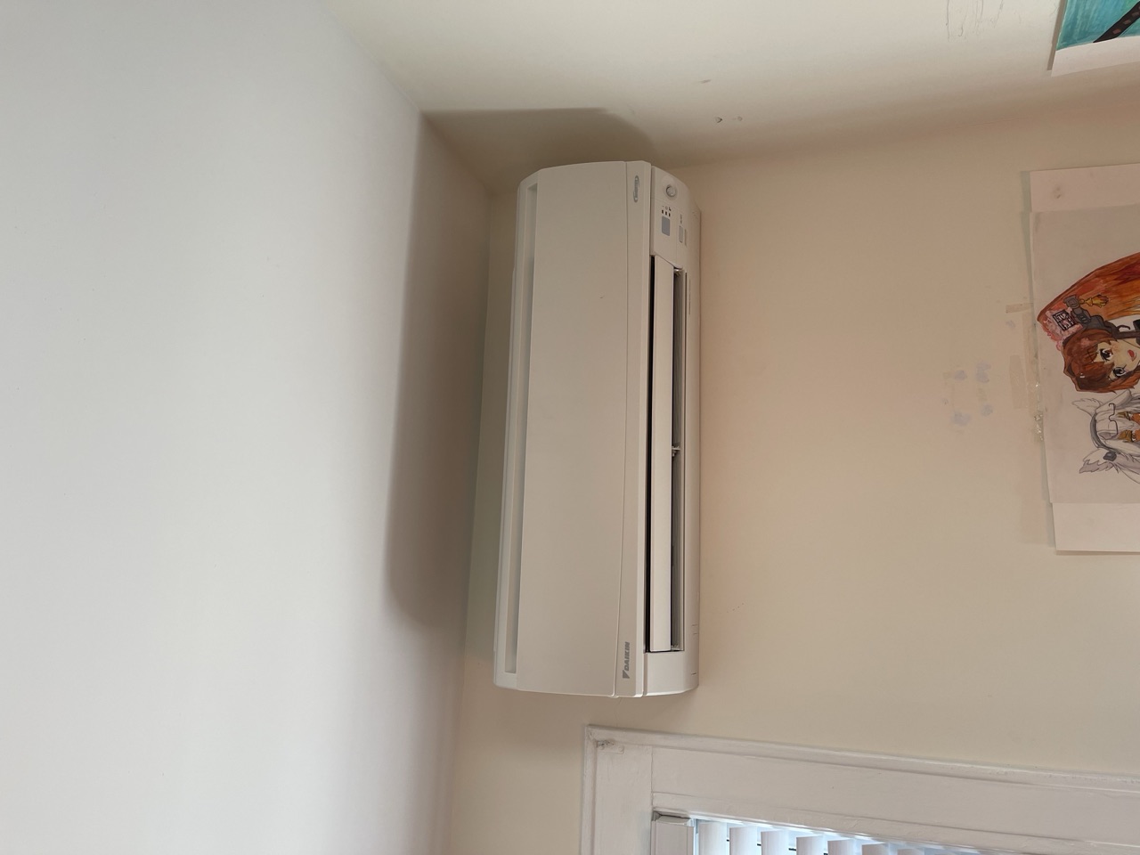 Daikin wall-mounted ductless air handler installed high on a bedroom wall above a doorway in a Brooklyn home