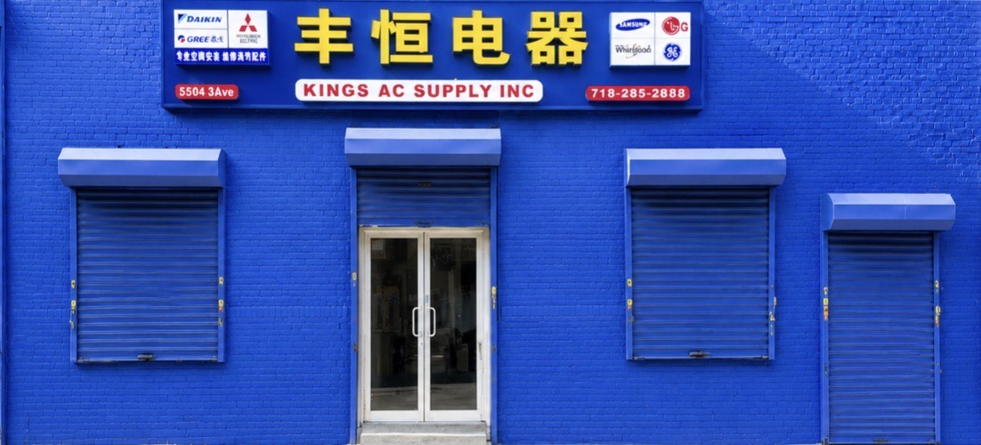 Kings AC Supply 丰恒电器 bright blue storefront at 5504 3rd Avenue, Brooklyn — authorized dealer of Daikin, Gree, Mitsubishi, Hyundai, Samsung, LG, Whirlpool and GE with phone number 718-285-2888 on the sign